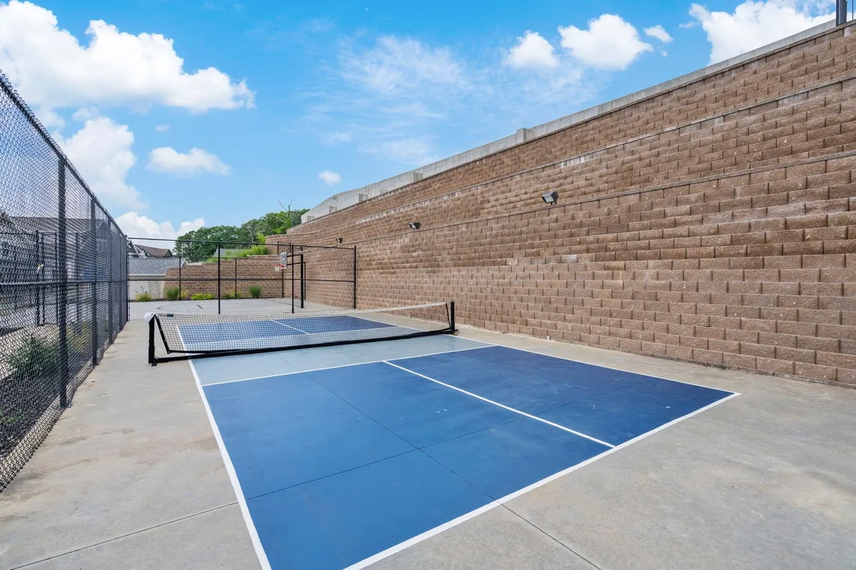 Well-maintained pickleball courts surrounded by fencing, inviting players to join in friendly matches or community events. The energy of the scene hints at both active recreation and opportunities to socialize outdoors.